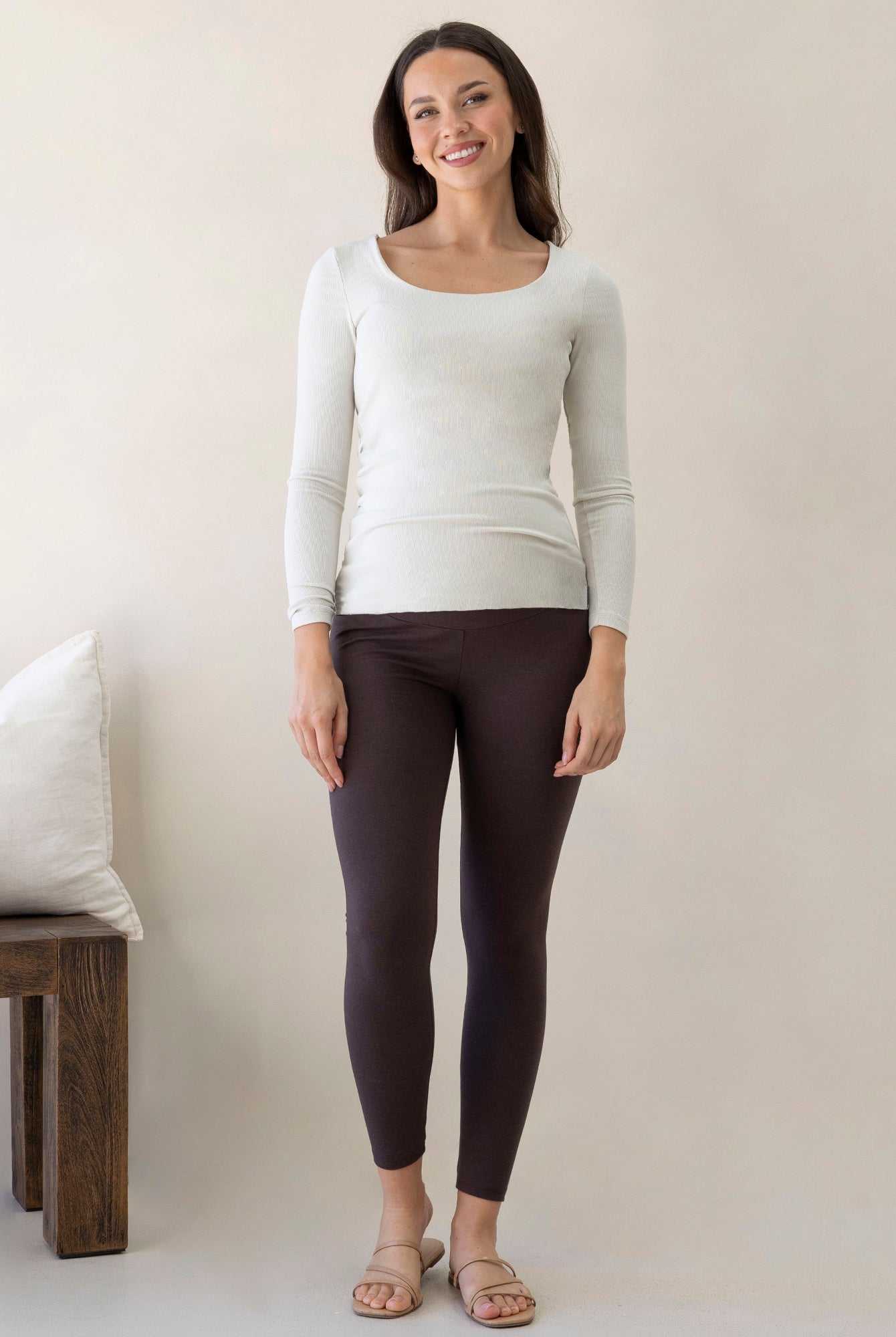 Angel Maternity white long sleeve maternity top paired with dark leggings worn by pregnant model