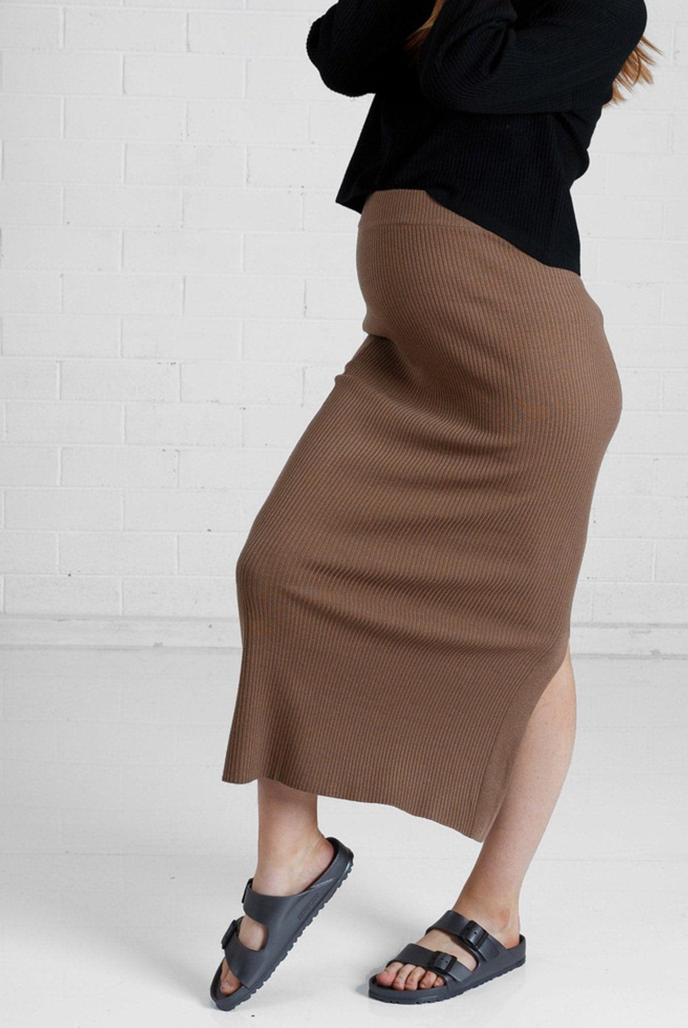 a woman in brown maternity angel maternity wool blend knit skirt with side split, side (6651643461735)