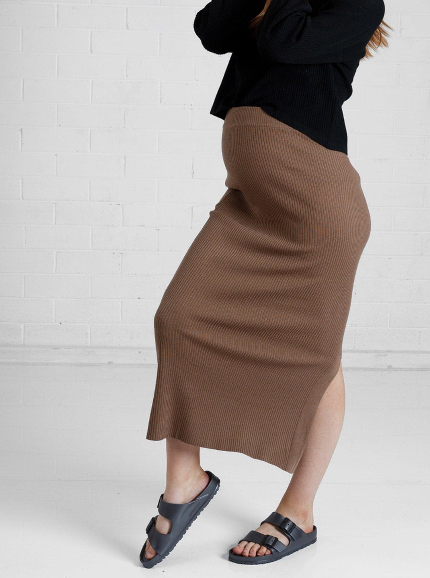 a woman in brown maternity angel maternity wool blend knit skirt with side split, side (6651643461735)