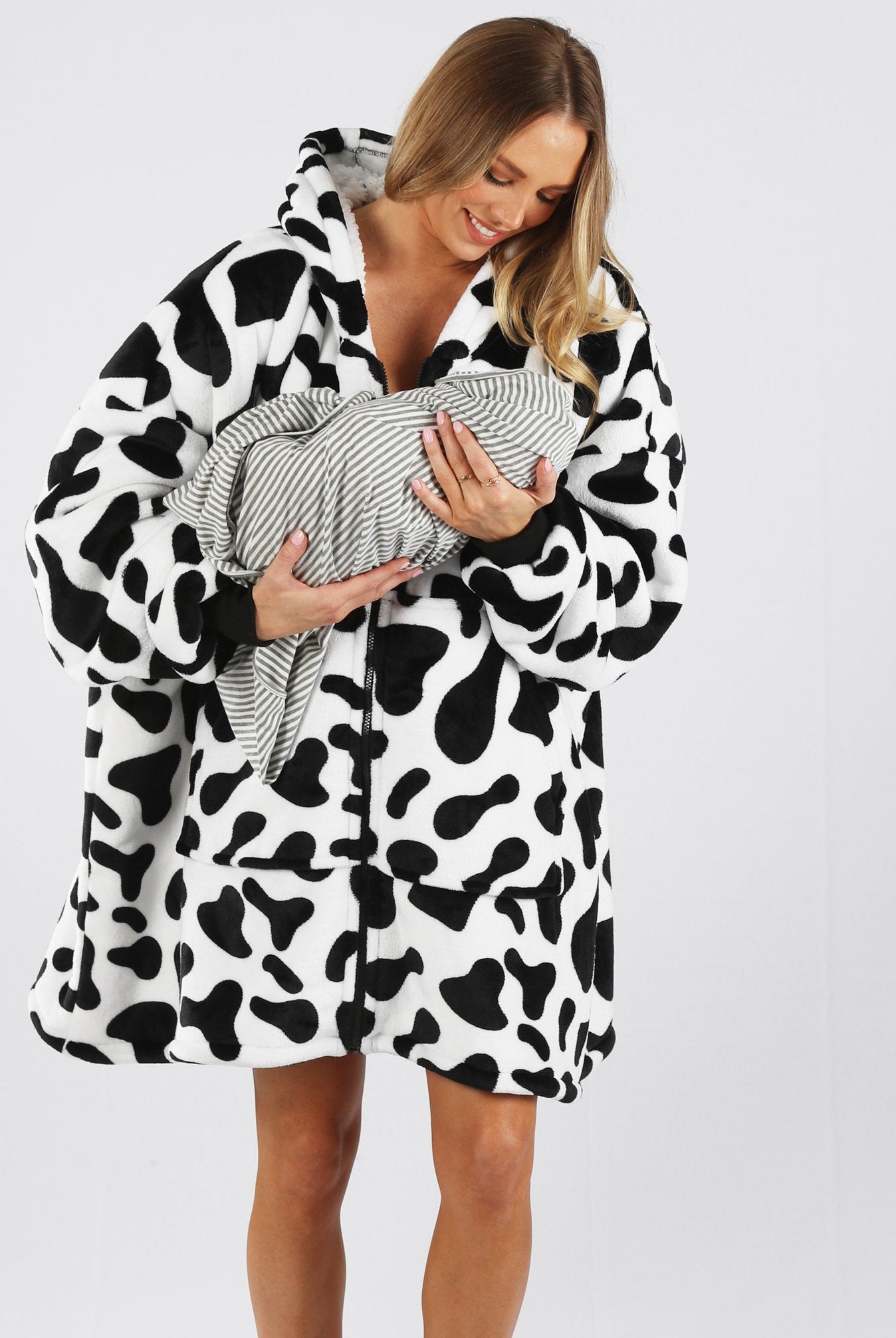 Main view - A pregnant woman in cow print front zip maternity & nursing blanket hoodie holding baby & smiling (6724236804190)