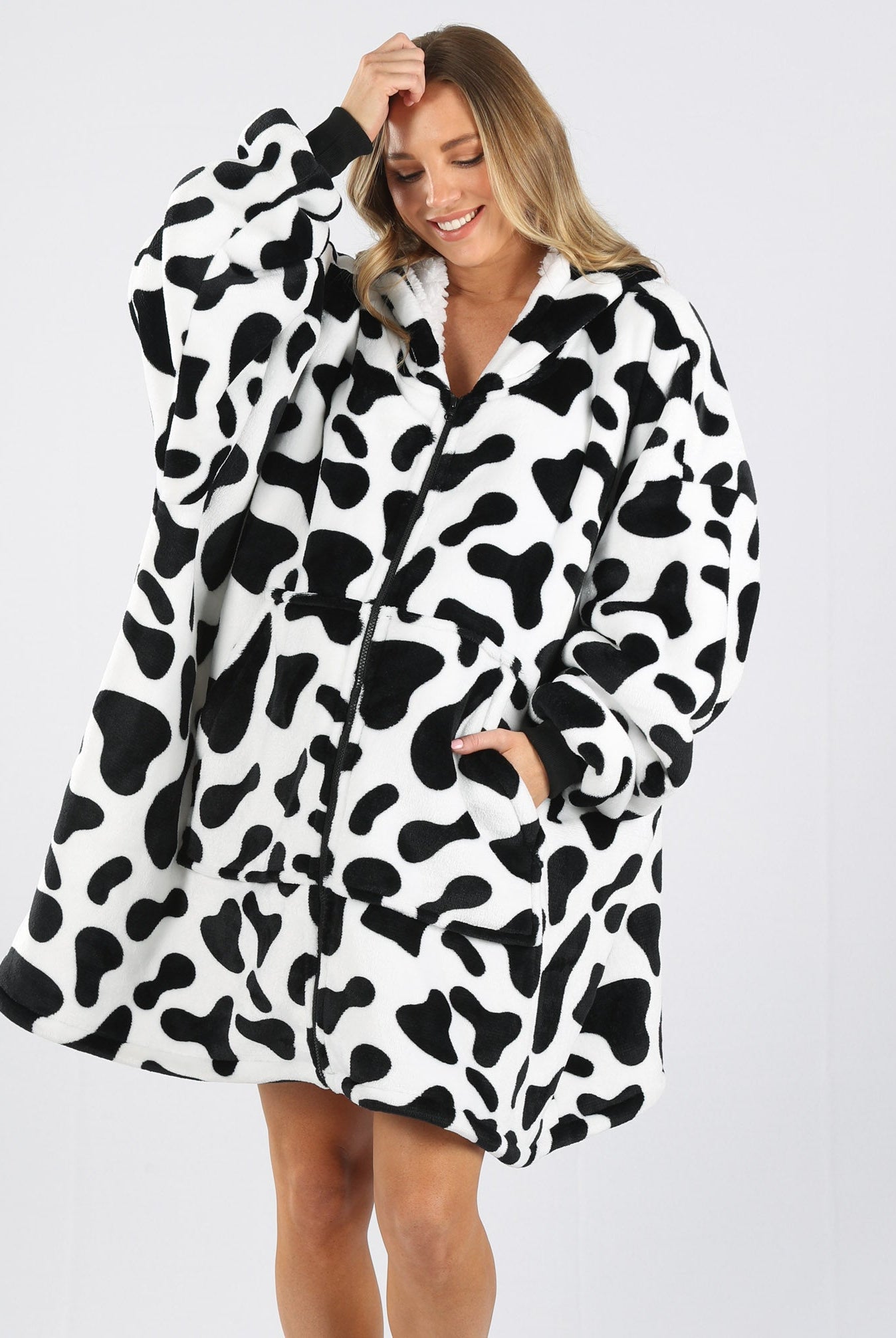 Front view - A pregnant woman in cow print front zip maternity & nursing blanket hoodie one hand in pocket smiling (6724236804190)