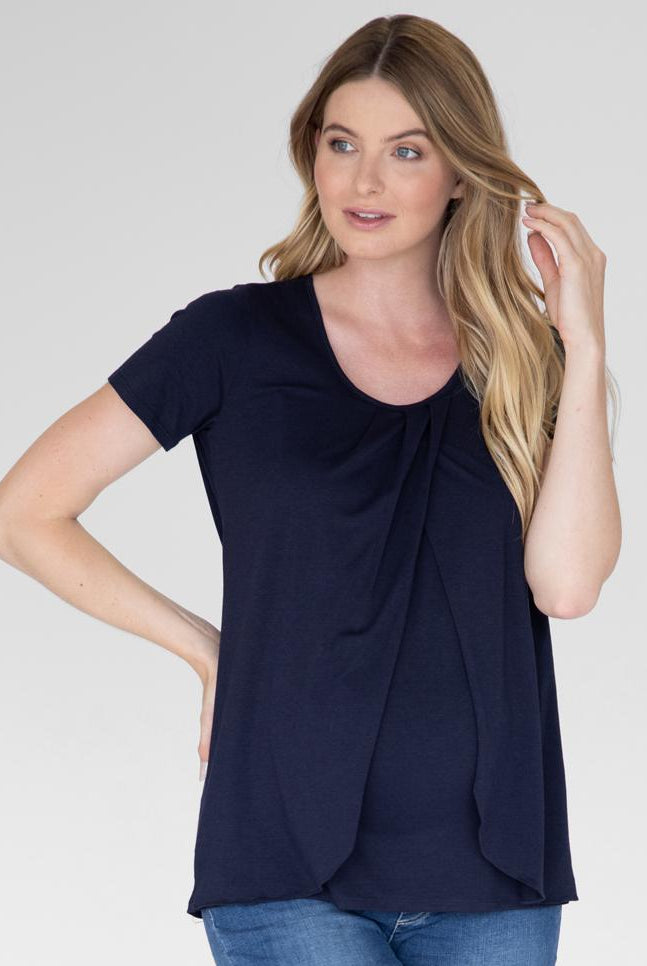Front view - A woman in petal front short sleeve nursing top in navy (4828435513438)