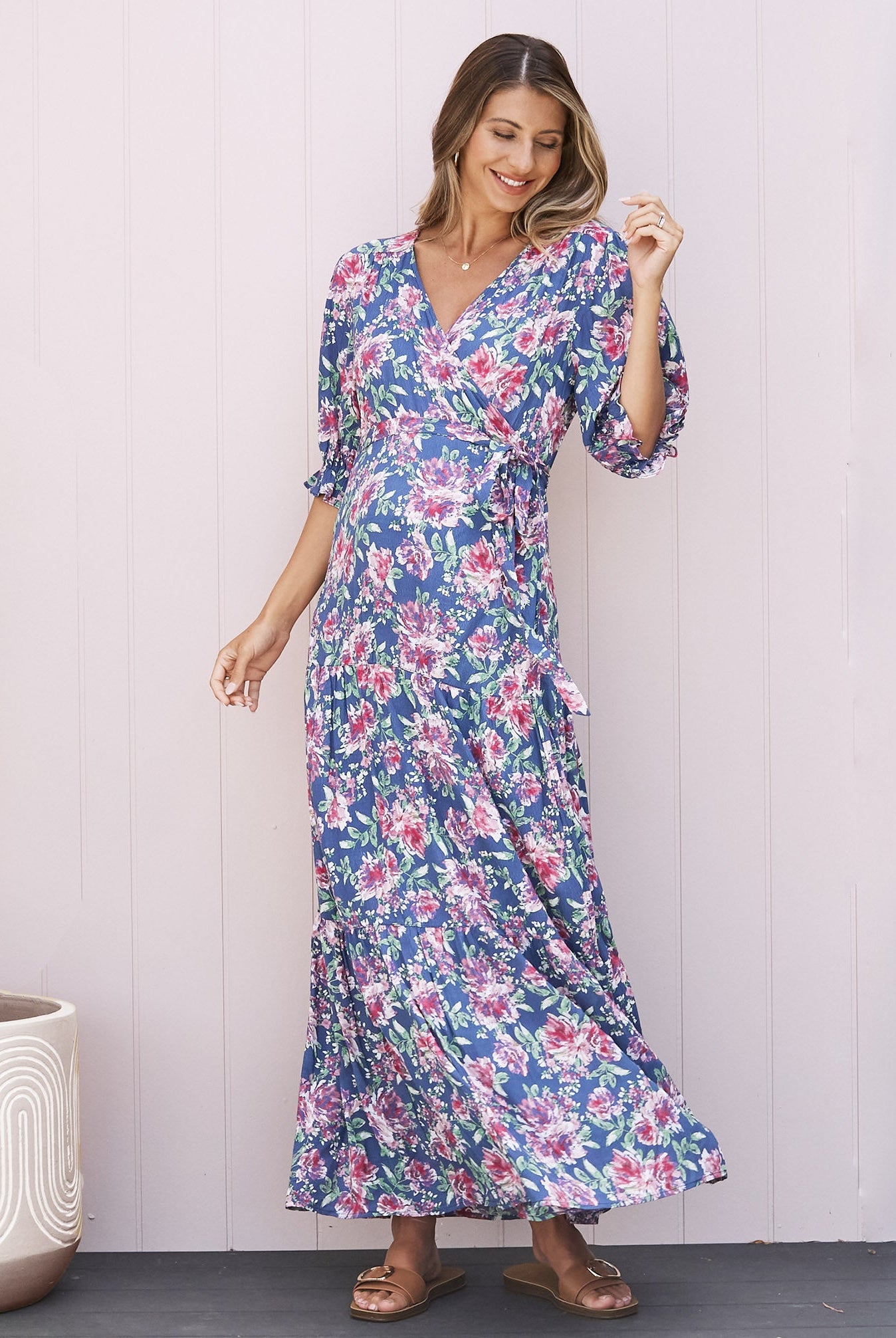 A Pregnant Woman in Elise Baby Shower Maternity Wrap Dress in Blue Flora from Angel Maternity