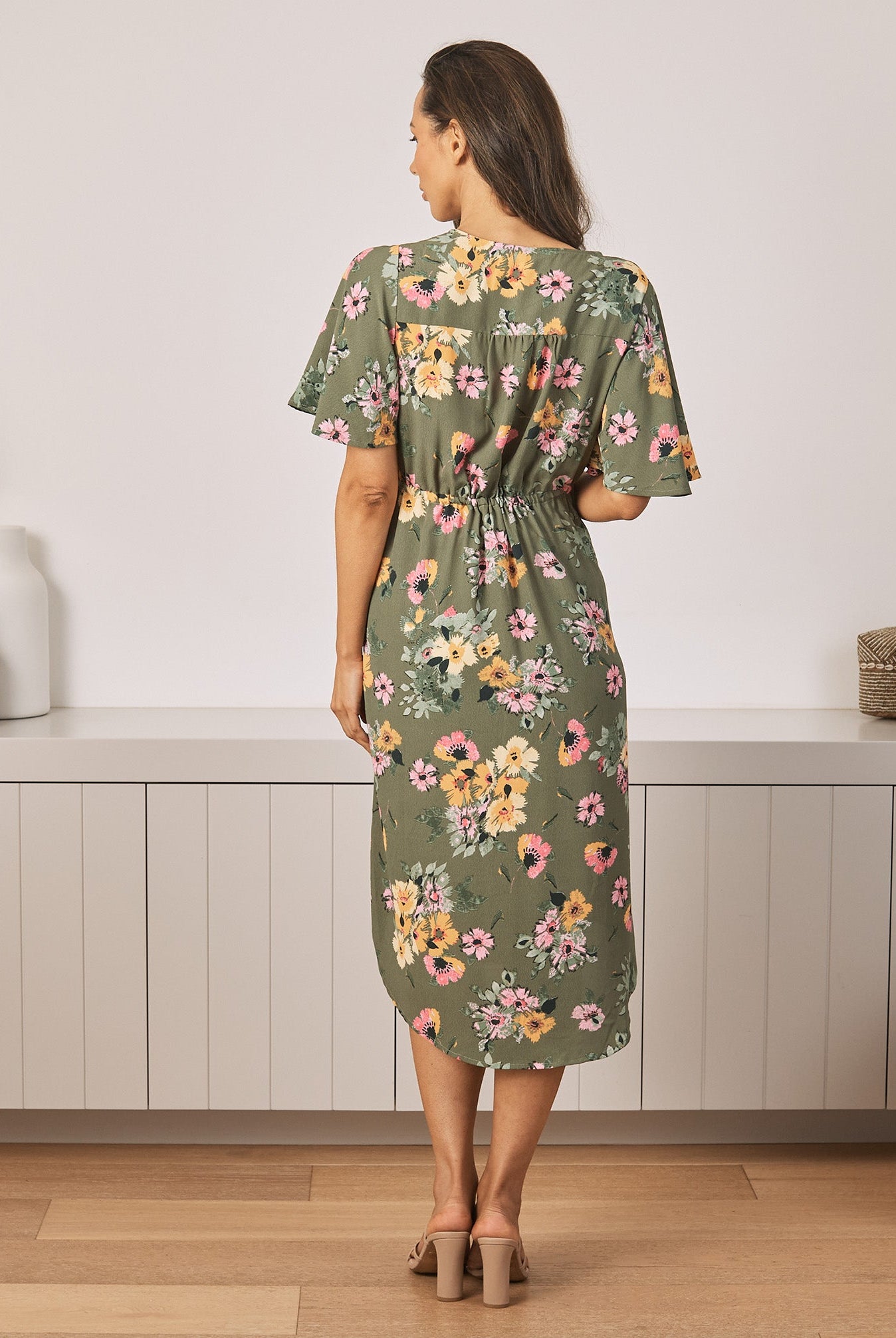 Back View - A Young Pregnant Woman in Floral Maternity Dress in Yellow Flora in Green Colour