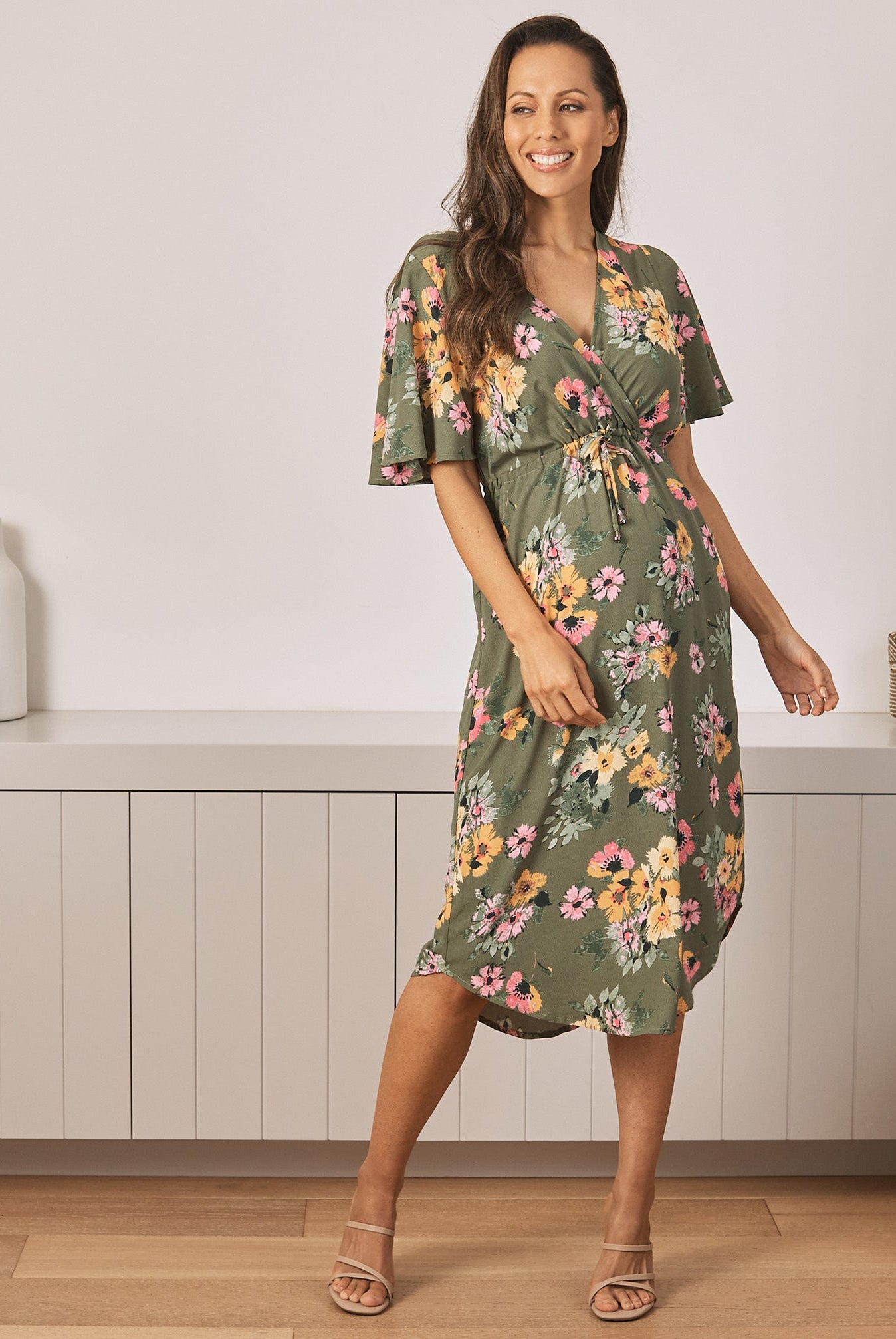 Main View - A Young Pregnant Woman in Floral Maternity Dress in Yellow Flora in Green Colour