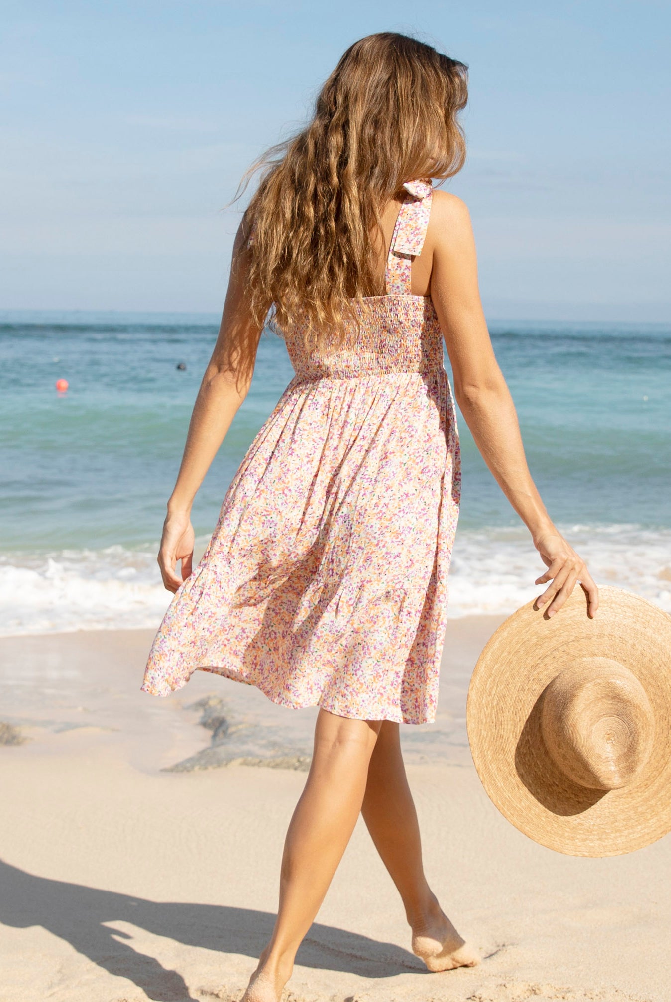 Back view - A pregnant woman in Shoulder Tie, Knee Length, Floral Print Maternity Sun Dress walking on the beach (6681440714846)