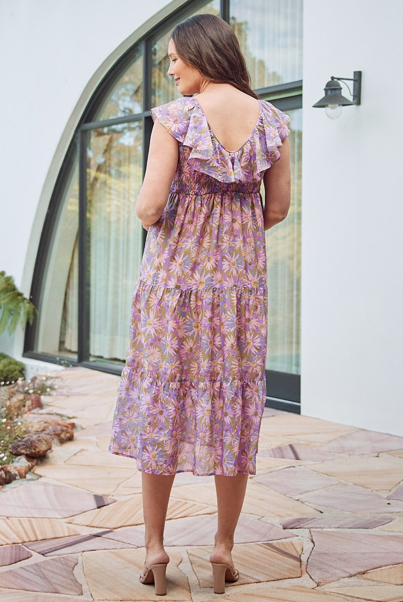 Back View - A Pregnannt Woman Wearing Daphne Reversible Floral Maternity Baby Shower Dress in Lilac from Angel Maternity.