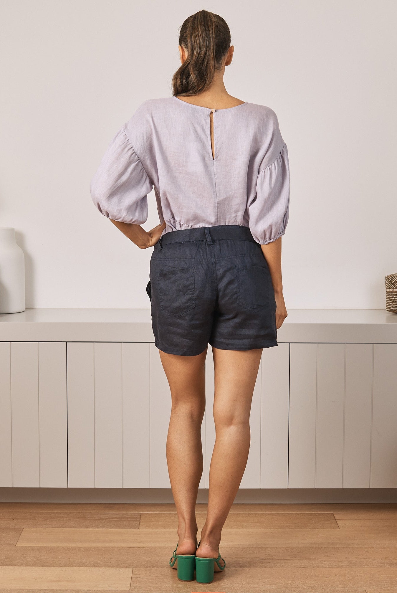 Back View - A Young Pregnant Woman in Summer Low Waist Maternity Linen Shorts in Navy Blue Colour
