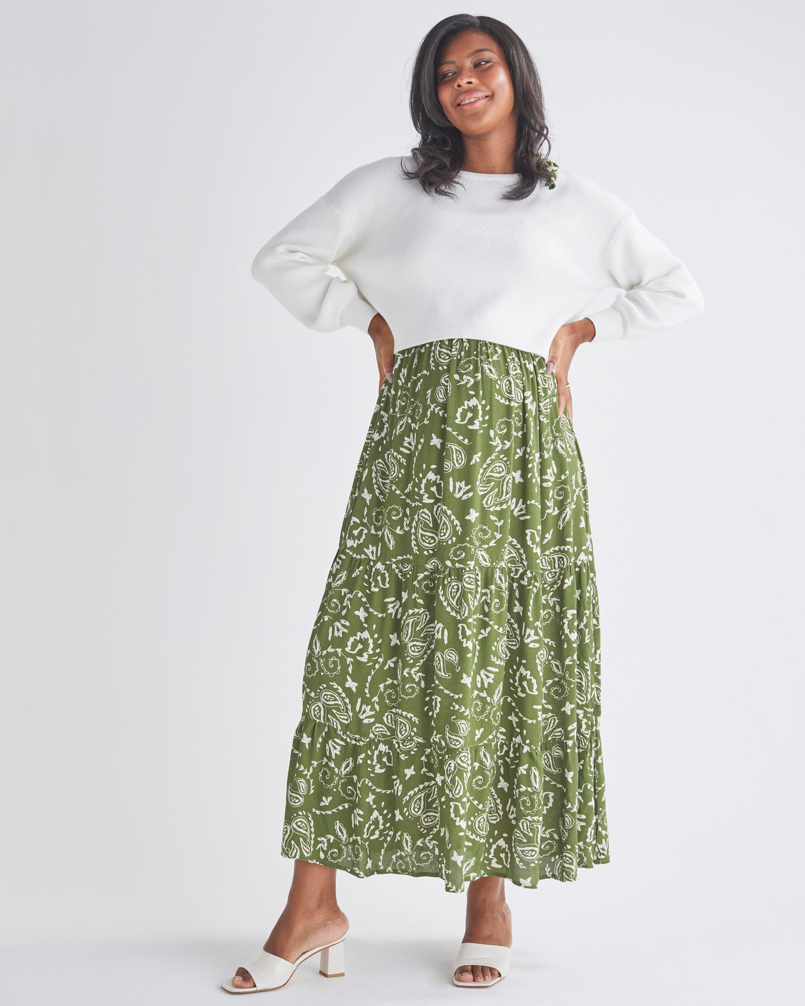 A Pregnant Woman Wearing Lilliana Maternity Green Dress in Paisley Print and White Top from Angel Maternity