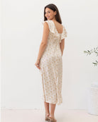 Woman wearing a floral dress with ruffled sleeves on a white background