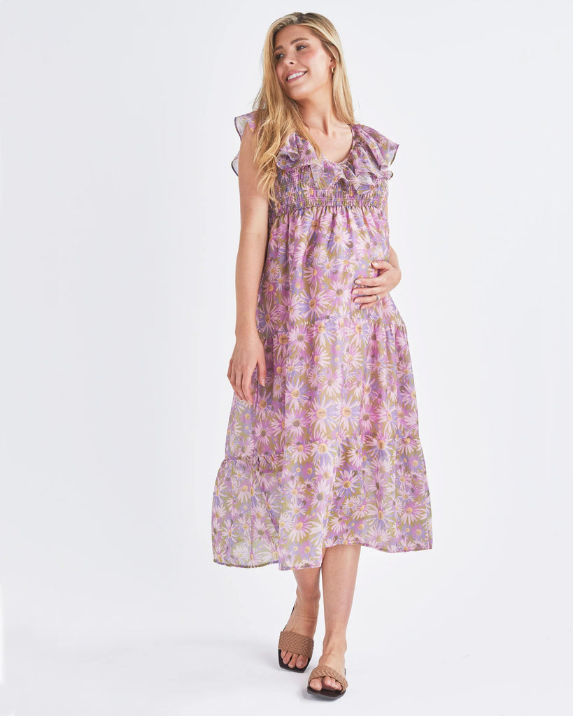 A Pregnant Woman Wearing Reversible Floral Maternity Baby Shower Dress in Lilac from Angel Maternity