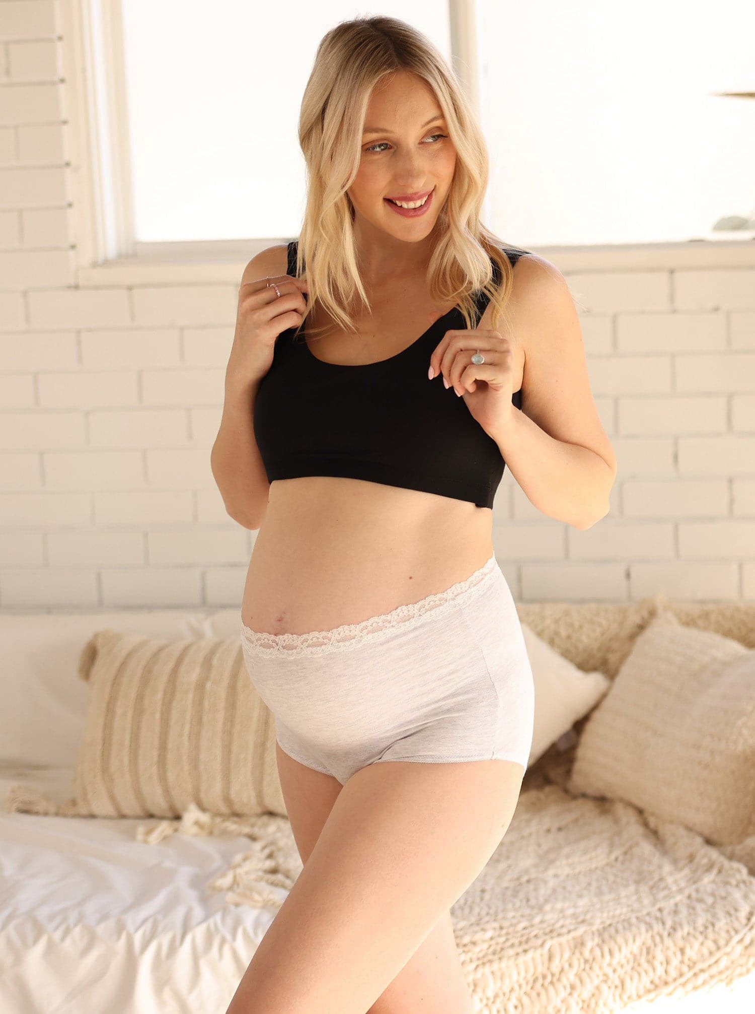 Close Up of Pregnant Woman in White Underwear Putting on a Bandage