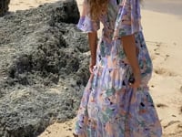 A woman in floral lavender maternity baby shower dress, video