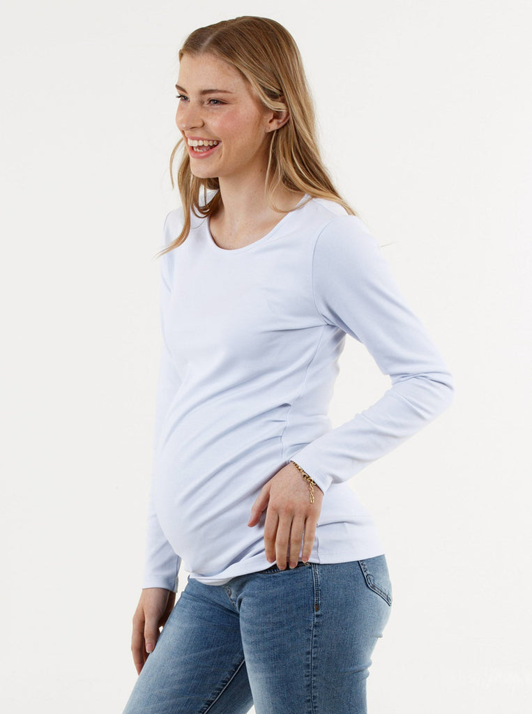side view -  A young pregnant woman in Basic White Long Sleeve Cotton Maternity Top smiling (6669517160542)