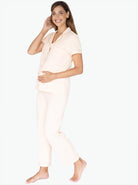 Main view -  A young pregnant woman in Button Front Maternity & Nursing Pajama Set in Peach touching her bump & smiling  (6659036872798)