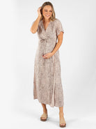 Full view - A woman in beige leopard print maternity nursing wrap dress, (6659012821086)