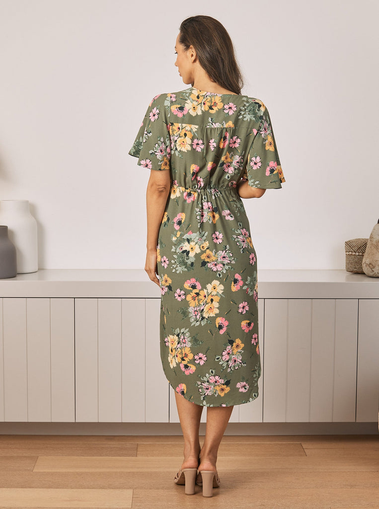 Back View - A Young Pregnant Woman in Floral Maternity Dress in Yellow Flora in Green Colour
