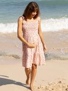 Front view - A pregnant woman in Shoulder Tie, Knee Length, Floral Print Maternity Sun Dress walking on the beach (6681440714846)