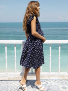 A woman in linen maternity spot dress, side (6681442353246)