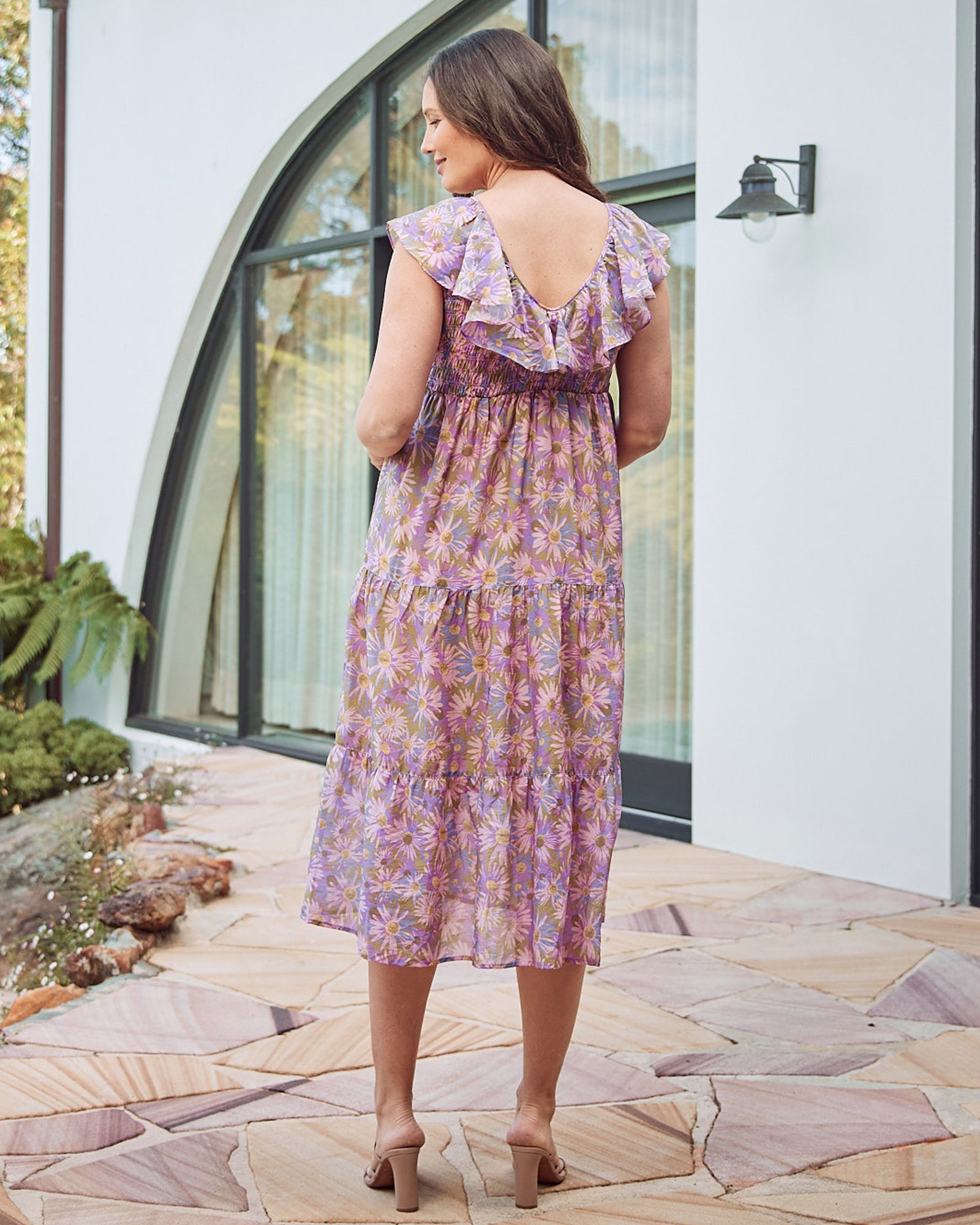 Back View - A Pregnannt Woman Wearing Daphne Reversible Floral Maternity Baby Shower Dress in Lilac from Angel Maternity.