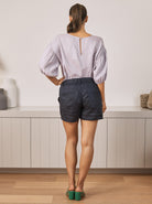 Back View - A Young Pregnant Woman in Summer Low Waist Maternity Linen Shorts in Navy Blue Colour
