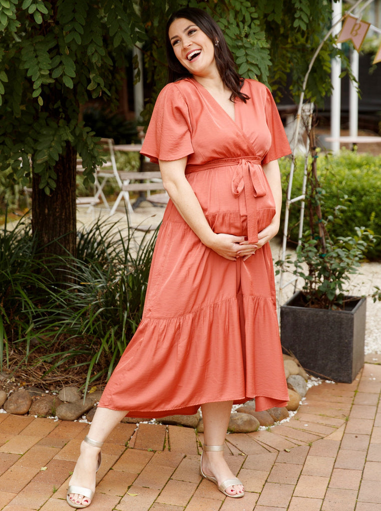 A woman in rust maternity dress, front (6677167865950)